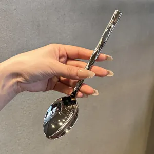 Close-up of stainless steel dinner spoon with diamond faceted handle and mirror finish.