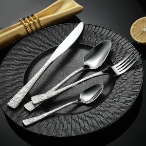 Juego de cubiertos de acero inoxidable con mango de textura corteza, vajilla elegante.