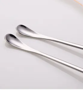 Close-up detail view of long handle stainless steel mixing spoon with polished finish.