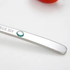 Stainless steel baby fruit puree spoon with 304 material and blue crystal decor detail.