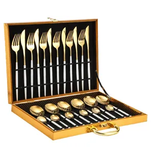 Stainless steel 24-piece cutlery set with gold finish and white handles in gift box detail view.