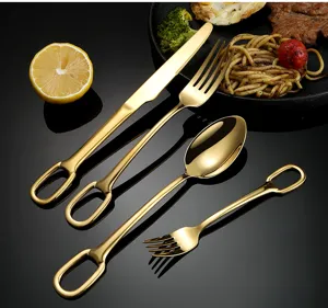 Golden stainless steel cutlery set detail, creative hanging hole design, luxury tableware.