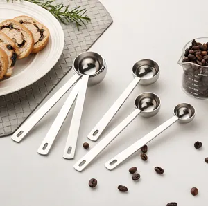 Detailed shot of stainless steel measuring spoons set with coffee beans and baking props.