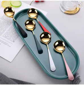 Juego de cucharas de acero inoxidable con cabezas doradas y mangos de colores en bandeja.