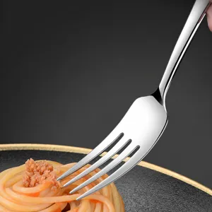 Stainless steel dinner fork for dining table, close-up view picking up spaghetti.