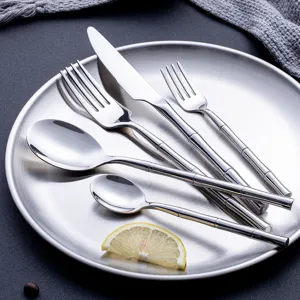 Set de couverts en acier inoxydable avec poignée design bambou pour une table élégante.