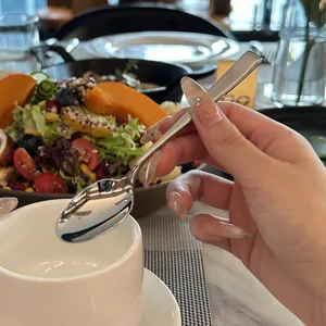 Detalle de cuchara de acero inoxidable, elegante cuchara de postre y café en restaurante.
