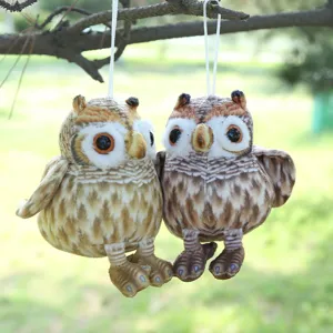 Dettaglio ravvicinato del simpatico peluche a forma di gufo appeso a un ramo.