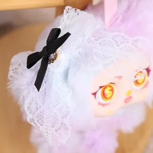 Gros plan détaillé d'un adorable pendentif de poupée en peluche violette avec voile en dentelle.