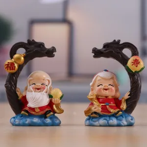 Close-up view of miniature resin Fu Shou elderly couple figurines with dragon arch decor.