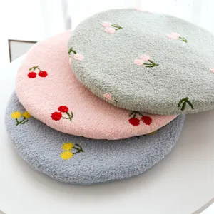 Close-up detail of the soft round pet cushion featuring cute cherry embroidery in cozy plush.