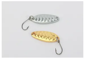Dettaglio esca da pesca cucchiaio metallico, esca artificiale argento e oro lucida.