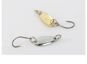 Primo piano di esche cucchiaino da pesca in metallo con ami singoli e anelli spaccati oro e argento.