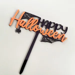 Vista detallada del adorno para pastel de Halloween de acrílico negro y naranja.