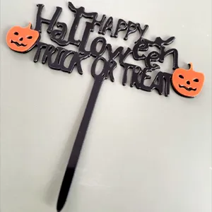 Primer plano detallado de un adorno de pastel de Halloween de acrílico negro y naranja.