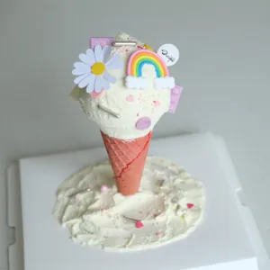 Kreatives DIY-Eiscreme-Kuchenmodell, rosa Waffelhörnchen mit Regenbogen und Gänseblümchen-Dekor.