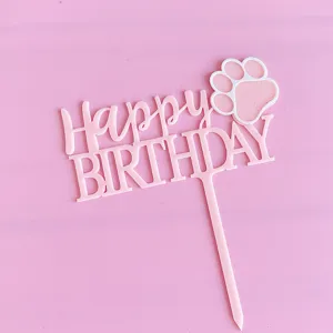Dettaglio topper torta compleanno animale in acrilico rosa, simpatico design zampa per festa.