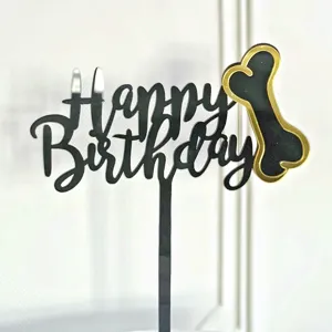 Primo piano di topper per torta di compleanno in acrilico nero con osso dorato per animali.