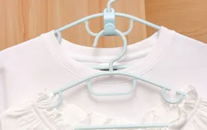 Detalle de primer plano de ganchos de conexion de perchas de plastico para ahorrar espacio.