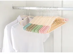 Detail view of adult plastic clothes hangers with anti-slip ends hanging on closet rod.