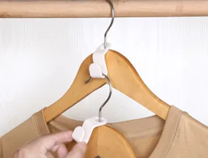 Ganchos de conexión de plástico blanco para perchas, ideales para ahorrar espacio en el armario.