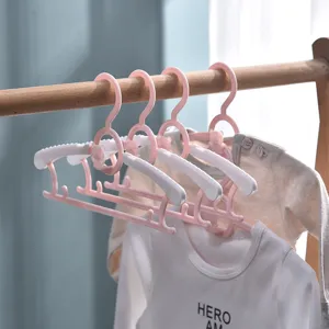 Cute pink folding baby clothes hangers with non-slip design and cartoon bear for infant nursery.