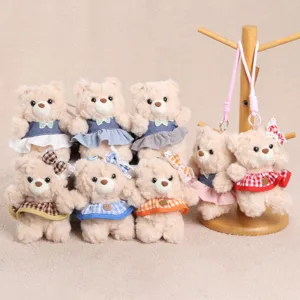 Close-up detail shot of cute plush teddy bear keychains featuring colorful plaid skirts and bows.