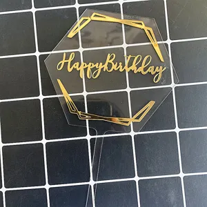 Détail de décoration de gâteau en acrylique transparent avec lignes géométriques or.