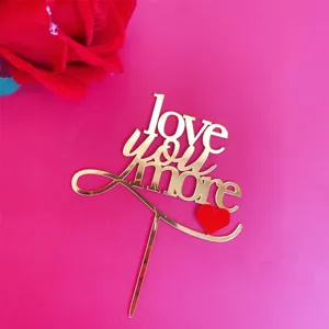 Gold acrylic love you more cake topper detail view, perfect for Valentine party desserts.
