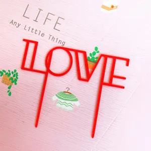 Red acrylic LOVE cake topper for Valentine's Day party dessert table decoration and celebration.