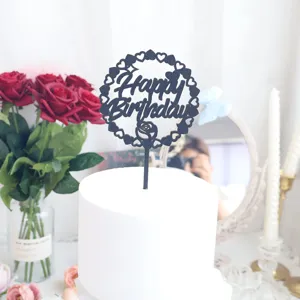 Primo piano dettagliato del topper per torta Happy Birthday nero glitterato con cuore e rosa.