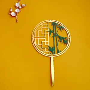 Detalle del topper de tarta acrílico estilo chino con diseño de abanico de bambú dorado.