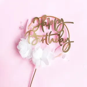 Χρυσό topper τούρτας Happy Birthday με λευκά λουλούδια από δίχτυ και πέρλες για πάρτι.