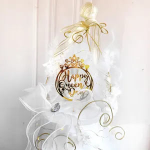 Detail view of the white feather gold crown cake topper for party celebrations.