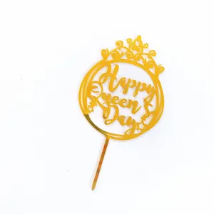 Gold acrylic cake topper detail showing the crown design and Happy Queen Day text cut out clearly.