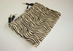 Detailed view of the zebra print pet hammock, showing durable metal clips and soft fabric.