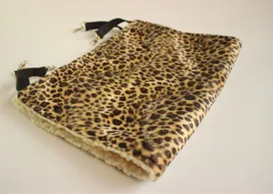Detailed close-up of a leopard print pet hammock with black straps and soft white plush lining.