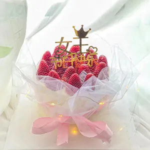 Detailed view of crown acrylic cake topper with white tulle and pink ribbon for celebration.