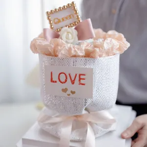 Détail d'emballage de bouquet de camélia avec nœud rose et carte d'amour pour fête des mères.