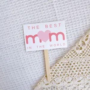 Detailed view of mother's day cake topper card with sweet pink heart design for celebration.