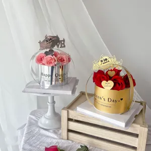 Boîte cadeau de roses pour la fête des mères avec arrangement floral, topper et ruban.