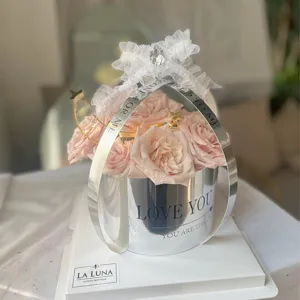 Coffret cadeau de roses roses luxueux avec poignee argente et beau noeud en dentelle fine.