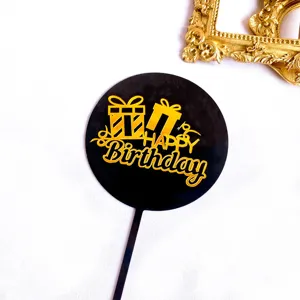 Gros plan détaillé du topper de gâteau en acrylique noir et doré avec texte de joyeux anniversaire.
