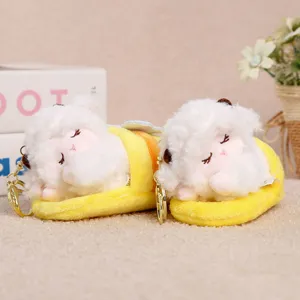 Detail view of cute plush sleeping sheep keychain toy in yellow slipper pouch accessory.