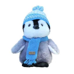 Cute penguin plush toy with blue knitted hat and scarf, soft stuffed animal for kids gift.