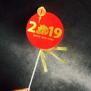 Décoration de gâteau du Nouvel An avec carte ronde rouge, impression dorée 2019, bâton et ruban.