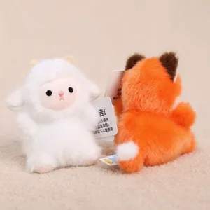 Close-up detail of cute plush animal keychain charms featuring a white lamb and fox.