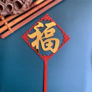 Close-up detail of a red and gold acrylic Fu cake topper with traditional design, dessert decor.