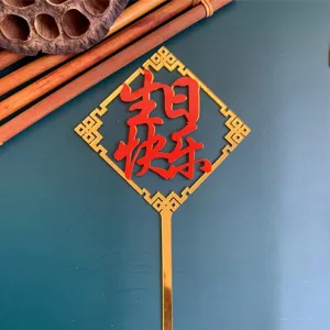 Close-up detail of Chinese style red and gold acrylic cake topper for birthday decor.