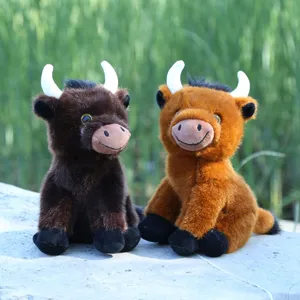 Vista detallada de lindos peluches de vacas de las tierras altas sentados afuera.